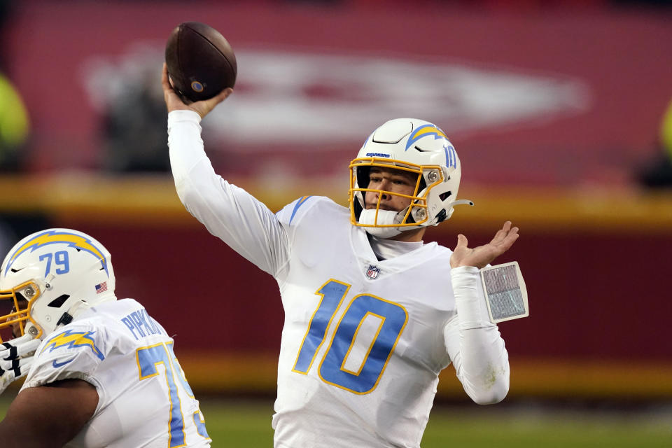 FILE - In this Jan. 3, 2021, file photo, Los Angeles Chargers quarterback Justin Herbert throws a pass during the first half of an NFL football game against the Kansas City Chiefs in Kansas City. Herbert has had a busy four weeks since the Chargers ended their season, but he already has set his sights on what will be another transitional offseason for him. (AP Photo/Charlie Riedel, File)