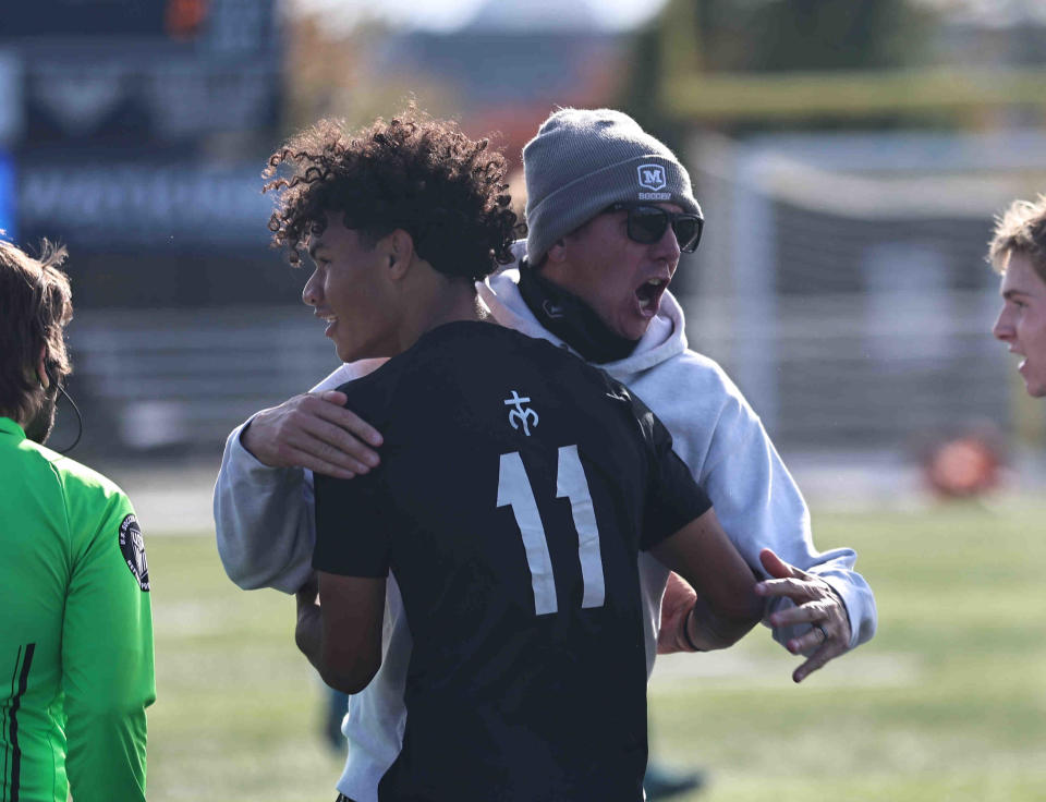 Moeller head coach Mike Welker celebrates with Michael Stocks (11) after the Crusaders' 2-0 win over St. Xavier in the regional final Saturday, Nov. 4, 2023.