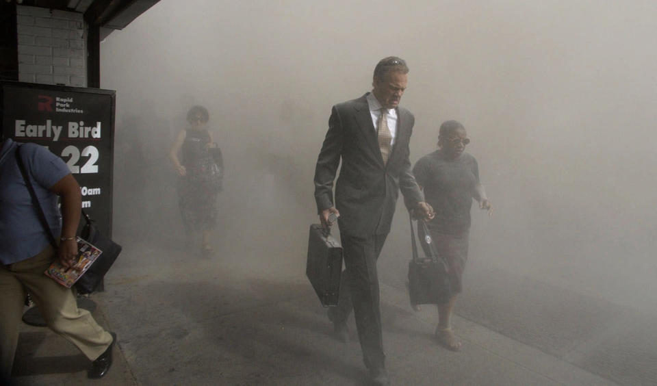 <p>Pedestrians on Beekman Street flee the area of the collapsed World Trade Center in lower Manhattan following a terrorist attack on the New York landmark, Sept. 11, 2001. (Photo: Amy Sancetta/AP) </p>