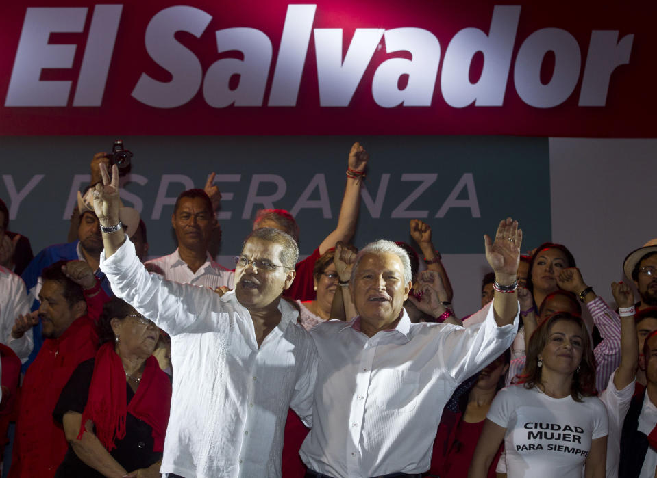 Presidential candidate Salvador Sanchez Ceren, of the ruling Farabundo Marti National Liberation Front (FMLN), right, and vice-presidential candidate Oscar Ortiz wave to supporters as they celebrate after partial results were announced by election authorities in San Salvador, El Salvador, Sunday, March 9, 2014. El Salvador's too-close-to-call presidential runoff election has raised competing claims of victory from Ceren, a former fighter for leftist guerrillas and the candidate of the once long-ruling conservative party that fought a civil war from 1980 to 1992, Norman Quijano but preliminary returns from nearly all polling stations showed Quijano a few thousands votes behind Ceren. (AP Photo/Esteban Felix)