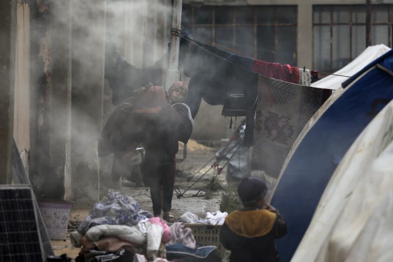 Internally displaced children walk outside tents in Azaz