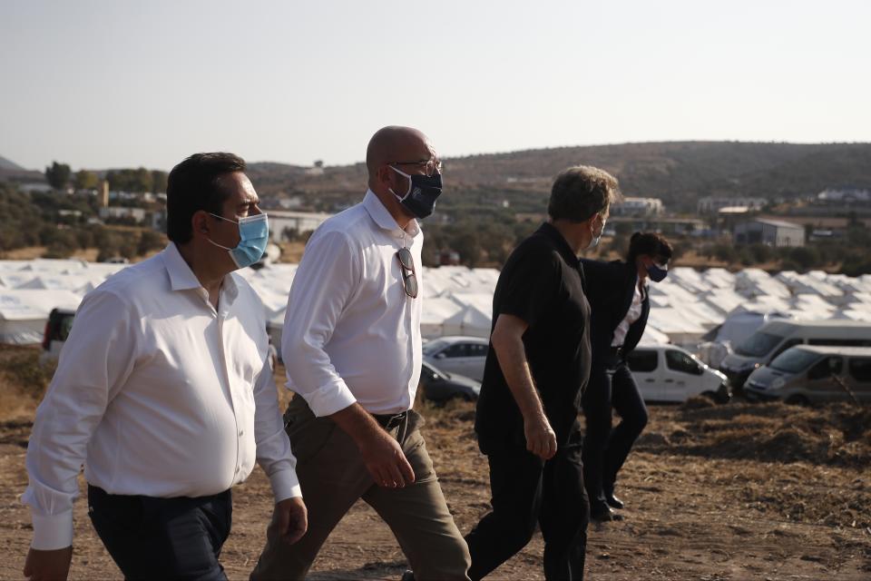 European Council President Charles Michel, center, is accompanied by Greek officials visits the new temporary refugee camp in Kara Tepe on the northeastern island of Lesbos, Greece, Tuesday, Sept. 15, 2020. Greece has called on the European Union to jointly run new refugee camps being built on its eastern islands as part of a planned overhaul of the bloc's migration policy. (Dimitris Tosidis/Pool via AP)