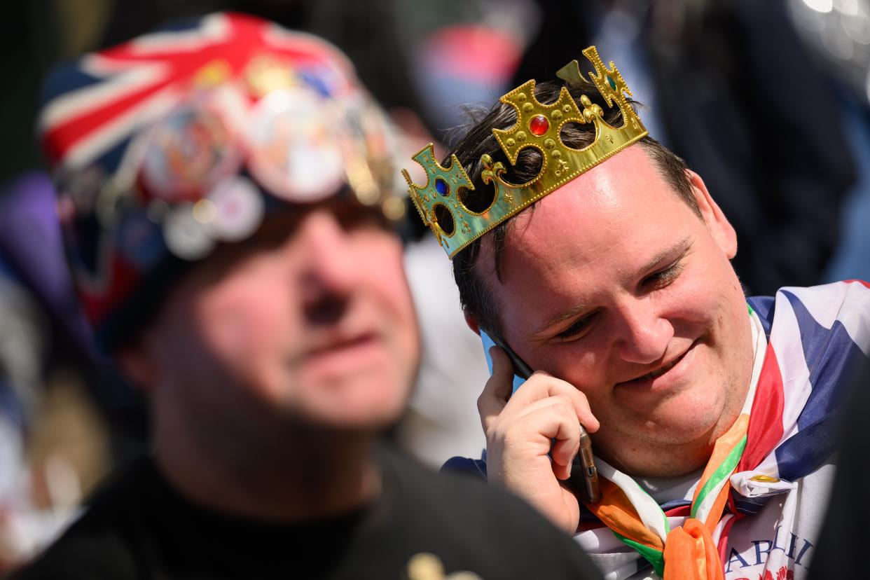 Royalists wear Union flag costumes and badges as they sit with their tents on the planned route of the Coronation procession (Getty Images)