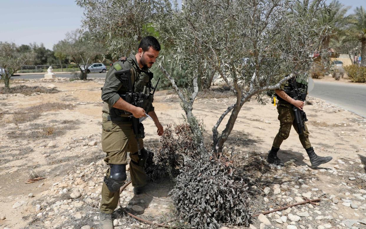 Israeli soldiers search for debris after the missile landed - AHMAD GHARABLI/AHMAD GHARABLI