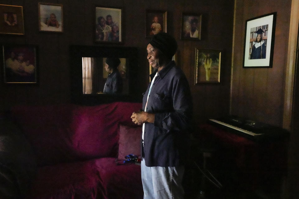 Carrie Jenkins stands in her living room by the light of her open front door, the only light in her home since losing power the night before in the aftermath of a severe storm, Friday, May 17, 2024 in Houston. (Brett Coomer/Houston Chronicle via AP)