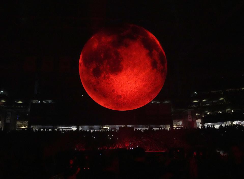 A moon hangs over fans as The Weeknd performs at State Farm Stadium in Glendale on Aug. 30, 2022.