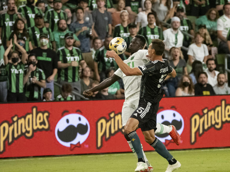 Austin FC forward Danny Hoesen, left, fights for the ball with LA Galaxy defender Daniel Steres, right, during the first half of an MLS soccer match, Sunday, Sept. 26, 2021, in Austin, Texas. (AP Photo/Michael Thomas)