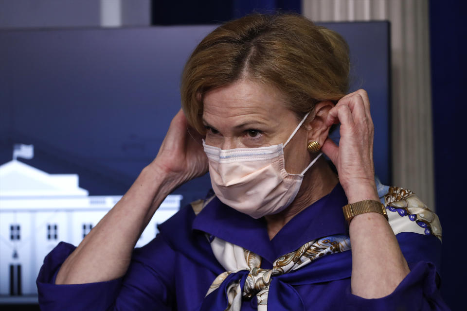 Dr. Deborah Birx, White House coronavirus response coordinator, puts on a face mask after speaking with reporters about the coronavirus in the James Brady Briefing Room of the White House, Friday, May 22, 2020, in Washington. (AP Photo/Alex Brandon)