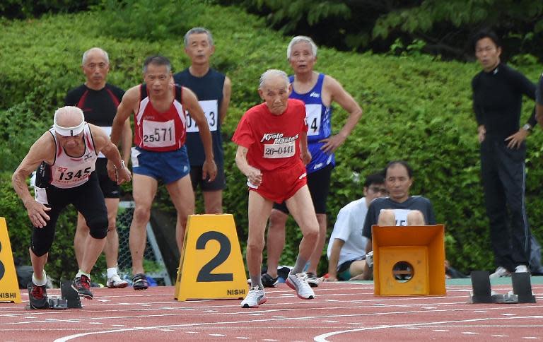 103-year-old Japanese sprinter Hidekichi Miyazaki (C) leaves the start line during the men's 100m dash at a competition in Kyoto on August 3, 2014