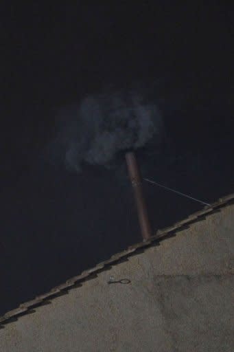 Photo Par Alberto Pizzoli - La place se vide rapidement alors que la fumée noire continue de sortir de la cheminée. Seuls les écrans permettent de la voir car elle est presque invisible dans le ciel de Rome où la nuit est tombée. "Je suis contente que la fumée soit noire, je pourrai revenir demain!", positive Luisa Fernanda Almagro, de Séville