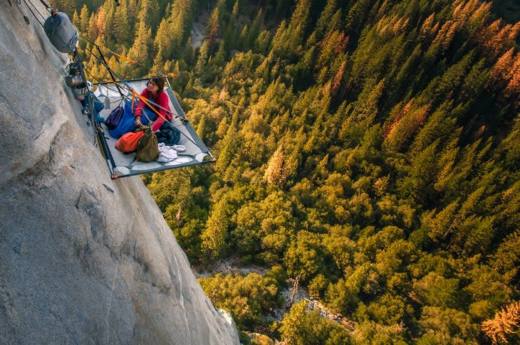 Woman looking up from portaledge on triple direct, El Capitan, high angle view, Yosemite Valley, California, USA