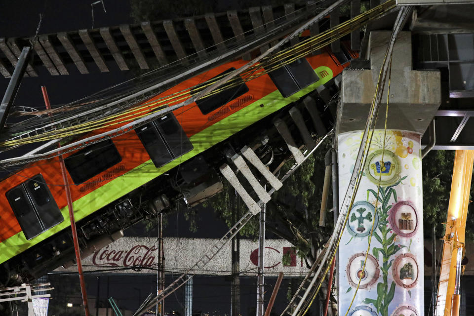 Mexico City's subway cars lay at an angle after a section of Line 12 of the subway collapsed in Mexico City, Tuesday, May 4, 2021. The section passing over a road in southern Mexico City collapsed Monday night, dropping a subway train, trapping cars, and causing at least 50 injuries and several dead, authorities said. (AP Photo/Marco Ugarte)