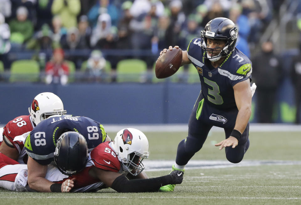 <p>Seattle Seahawks quarterback Russell Wilson, right, is tripped by Arizona Cardinals outside linebacker Chandler Jones, second from right, in the second half of an NFL football game, Sunday, Dec. 31, 2017, in Seattle. (AP Photo/Elaine Thompson) </p>