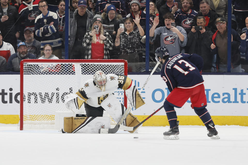 Vegas Golden Knights' Logan Thompson, left, makes a save against Columbus Blue Jackets' Johnny Gaudreau, right, during the shootout period of an NHL hockey game on Monday, Nov. 28, 2022, in Columbus, Ohio. (AP Photo/Jay LaPrete)