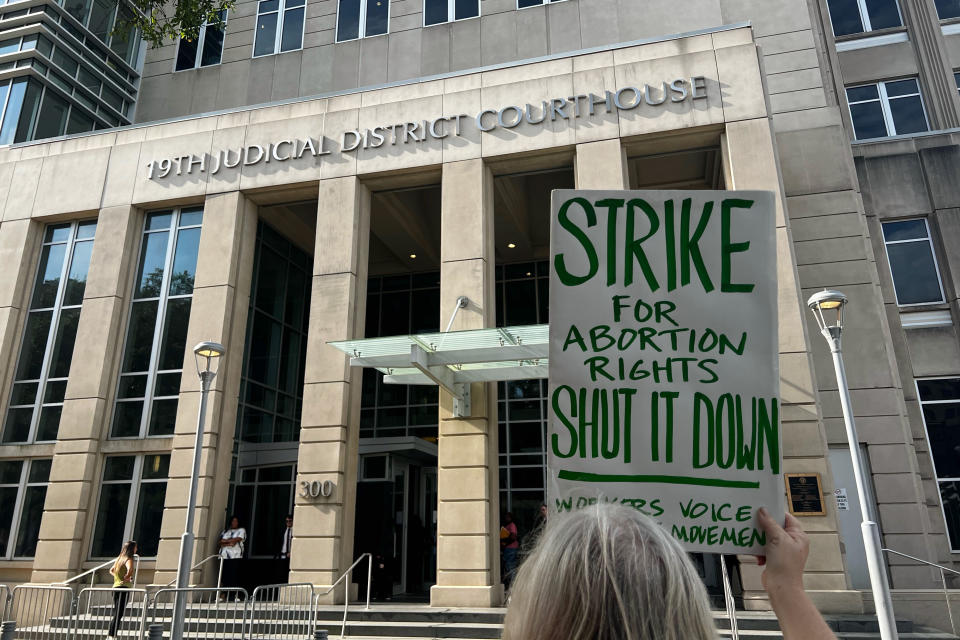 An abortion rights advocate demonstrates outside the 19th Judicial District Courthouse, Monday July 18, 2022, in Baton Rouge, La. (AP Photo/Stephen Smith)