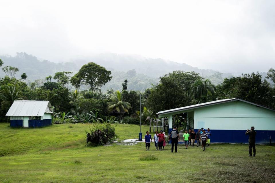 <div class="inline-image__caption"><p>A police officer photographs residents of the Ngabe Bugle indigenous jungle community of El Terron, Panama, on Jan. 17, 2020.</p></div> <div class="inline-image__credit">Arnulfo Franco/AP</div>