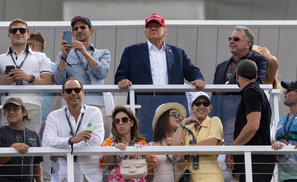 Former President Donald Trump, wearing red cap, looks on as drivers compete in the Formula One Miami Grand Prix at the Miami International Autodrome.