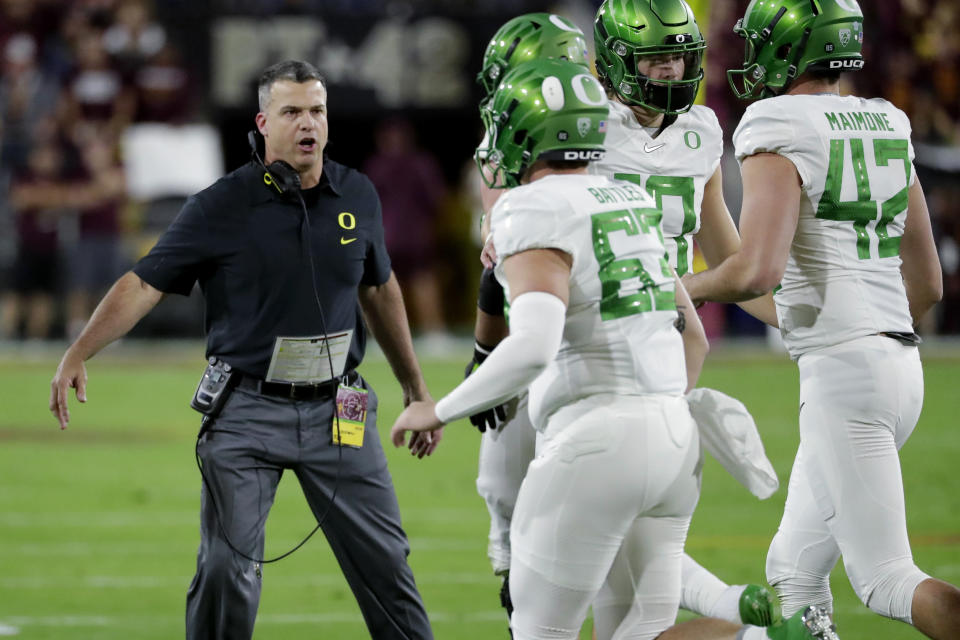 Oregon coach Mario Cristobal greets his team after a touchdown during the first half of an NCAA college football game against Arizona State, Saturday, Nov. 23, 2019, in Tempe, Ariz. (AP Photo/Matt York)