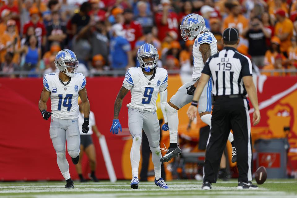 Amon-Ra St. Brown of the Detroit Lions and Josh Reynolds of the Detroit Lions celebrate with Jameson Williams of the Detroit Lions after Williams' receiving touchdown during the third quarter against the Tampa Bay Buccaneers at Raymond James Stadium on October 15, 2023, in Tampa, Florida.