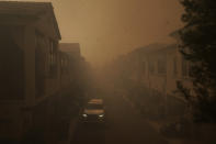 An SUV is parked in the evacuated residential area filled with heavy smoke from the Silverado Fire Monday, Oct. 26, 2020, in Irvine, Calif. A fast-moving wildfire forced evacuation orders for 60,000 people in Southern California on Monday as powerful winds across the state prompted power to be cut to hundreds of thousands to prevent utility equipment from sparking new blazes. (AP Photo/Jae C. Hong)