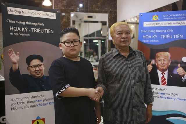 Le Phuc Hai, 66, and To Gia Huy, nine, pose for a photo after having Trump and Kim haircuts in Hanoi, Vietnam