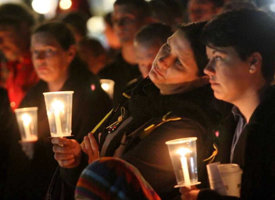 JOHN FITZHUGH/SUN HERALDWaffle House employees Kristie Bergeron of Ocean Springs, left, and Ashley Shaul of St. Martin hold candles in memory of their slain co-worker, Waffle House server Julie Brightwell, during a memorial service for her on the beach in Biloxi on Friday Dec. 4, 2015.