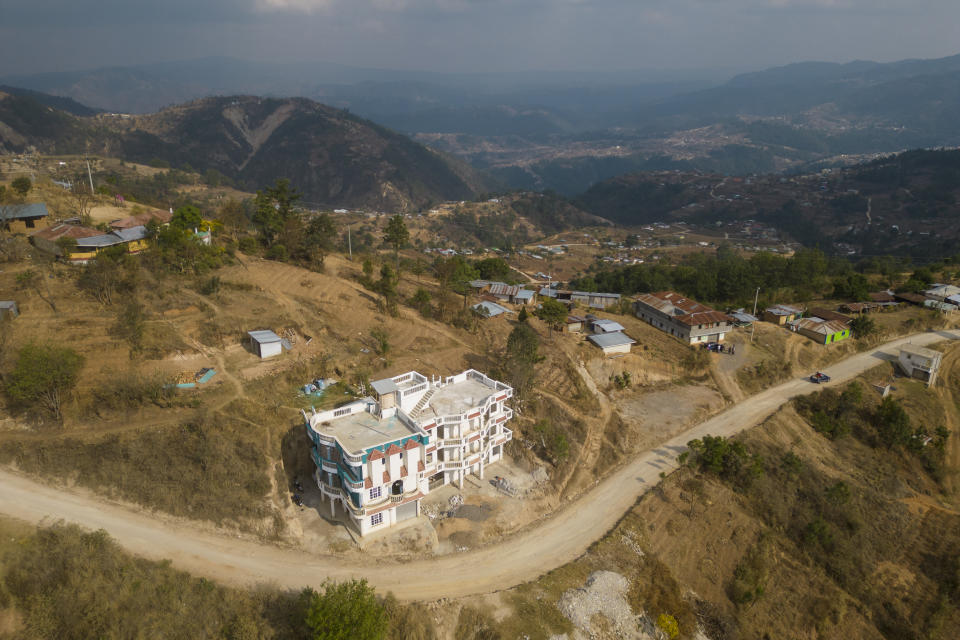 A home built with migrant remittances stands in the Loma Linda hamlet of Comitancillo, Guatemala, Monday, March 18, 2024. The multi-story concrete homes built with money made by loved ones in the United States are constant reminders of what’s possible if only one makes it “to the north.” (AP Photo/Moises Castillo)