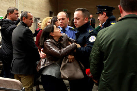 A family member reacts after hearing the verdict in the trial for four people, including a parliament member, accused of taking part in a grenade attack against the parliament building last year, in a courtroom in Pristina, Kosovo November 17, 2017. REUTERS/HAZIR REKA