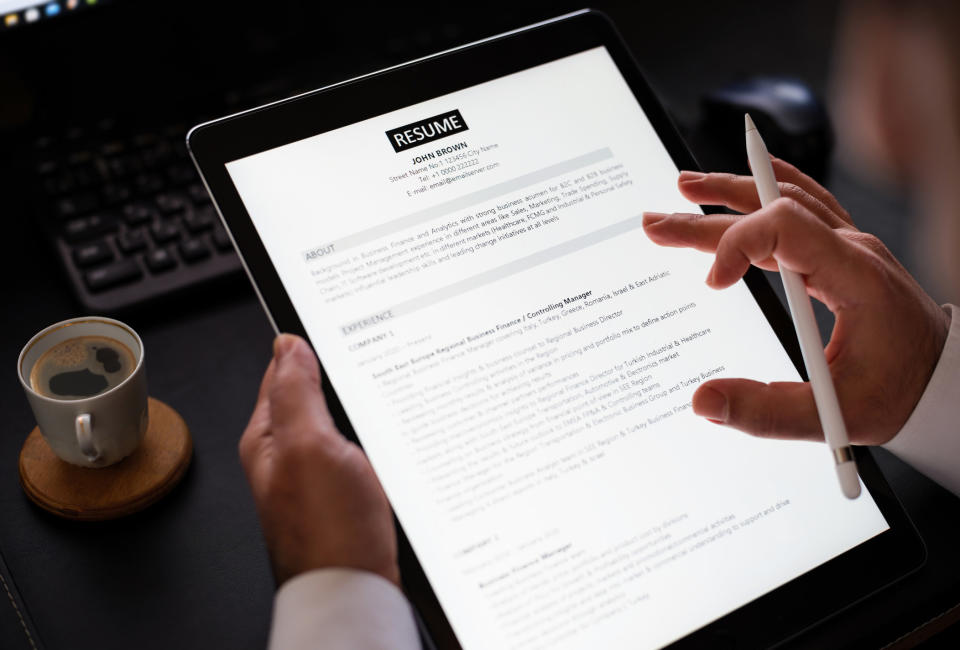 Person reading a résumé on a tablet