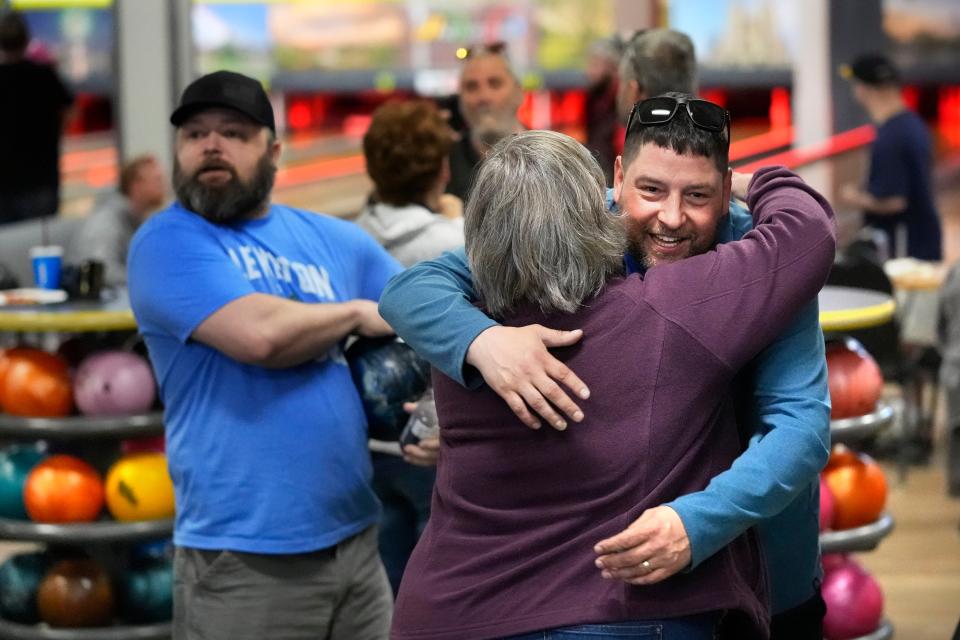 Justin Juray, owner of Just In Time Recreation, hugs a customer during the reopening of the bowling alley six months after a deadly mass shooting, Friday, May 3, 2024, in Lewiston, Maine. (AP Photo/Robert F. Bukaty)