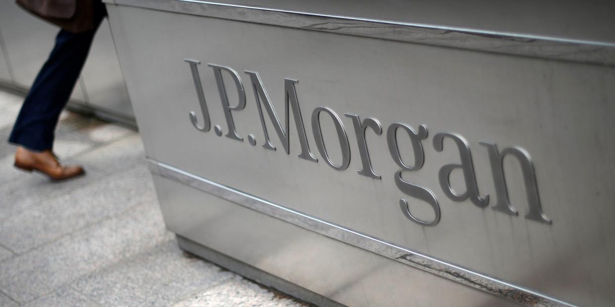 FILE PHOTO: A man walks into the JP Morgan headquarters at Canary Wharf in London May 11, 2012.  REUTERS/Dylan Martinez/File Photo    