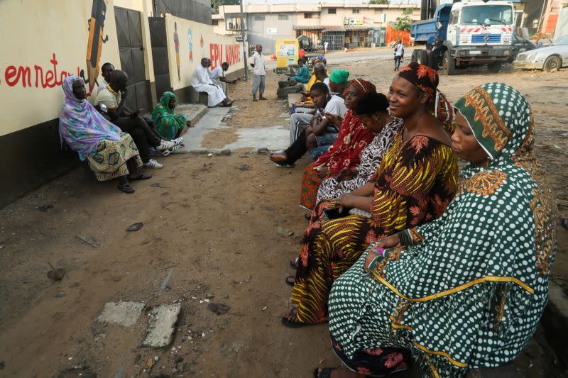 People wait for the opening of a polling office during the presidential election in Abidjan