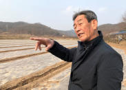 Kim Kwang-il, uncle of Kim Eun-jung, skip of South Korea's Olympic women's curling team, stands on a garlic field, in Uiseong, South Korea, February 23, 2018. REUTERS/Lucien Libert