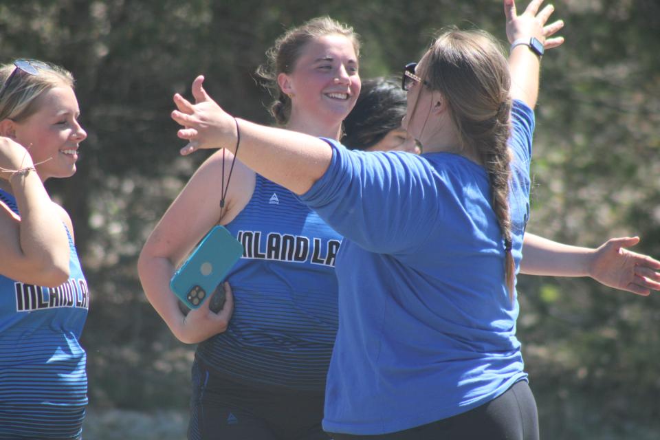 Inland Lakes senior Ashley Murray gets congratulated by coaches and teammates after finishing second in the girls shot put on Friday.