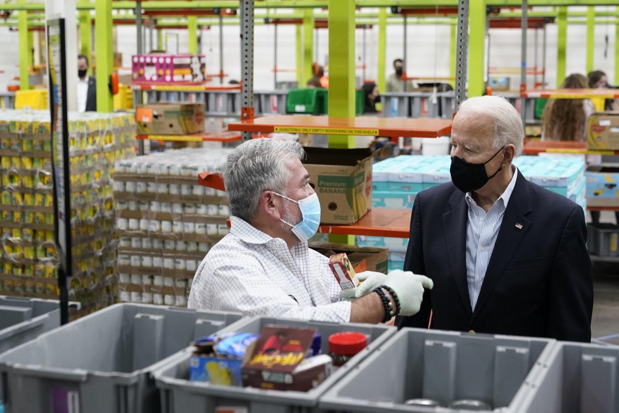 President Joe Biden speaks with a volunteer at the Houston Food Bank, Friday, Feb. 26, 2021, in Houston. 