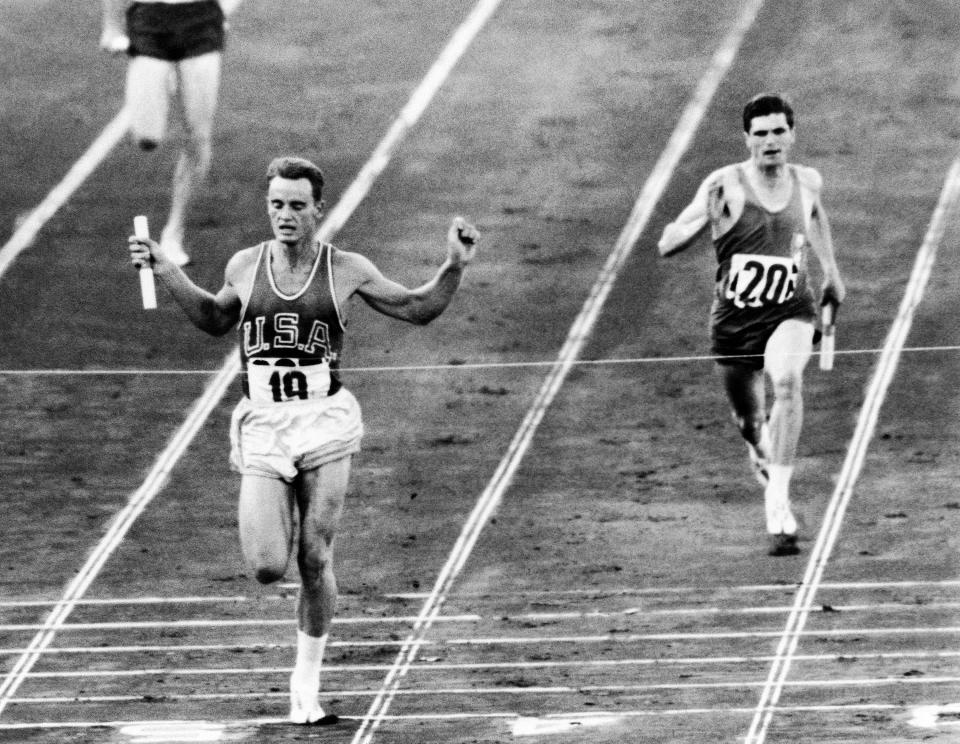 Dave Sime, left of USA, finishes first in heat 4 of the Summer Olympic Games Men's 4 x 100 meters reply in Rome, Italy on Sept. 7, 1960. Finishing at right is a French runner whose team was disqualified for a baton changeover outside its own lane. (AP Photo)