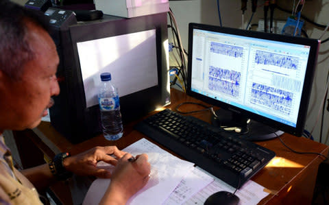 A man monitors seismic waves at the Mount Agung monitoring station at Rendang subdistrict in Klungkung regency on Bali  - Credit: SONNY TUMBELAKA/AFP/Getty Images