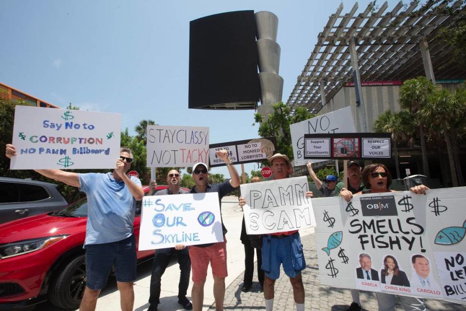 De izquierda a derecha: James Torres, Elvis Cruz, Kristen Browd y Michael Feuling participan en una protesta el 19 de mayo de 2024 en el downtown de Miami en la que se insta a los líderes de la ciudad a derogar una ley de 2023 que duplicó el límite de tamaño de las vallas publicitarias digitales en algunas ubicaciones junto al paseo marítimo de Miami.