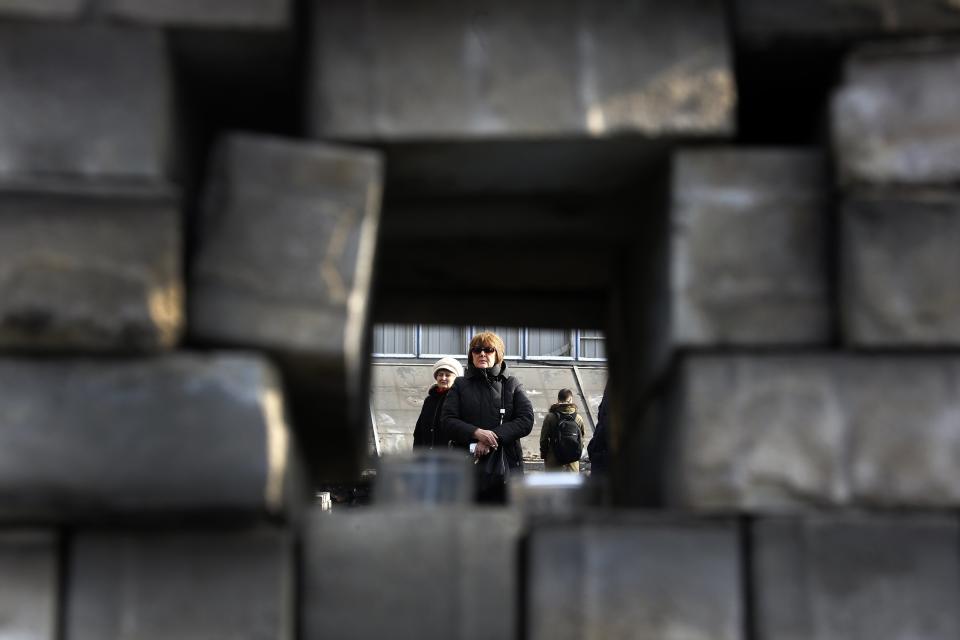 A mourner is seen through a barricade in Kiev's Independent Square