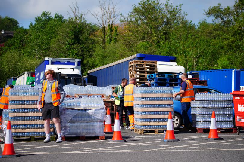 People collecting bottled water at Broadsands Car Park in Paignton. Around 16,000 households and businesses in the Brixham area of Devon have been told not to use their tap water for drinking without boiling and cooling it first, following the discovery of small traces of a parasite in the local water network