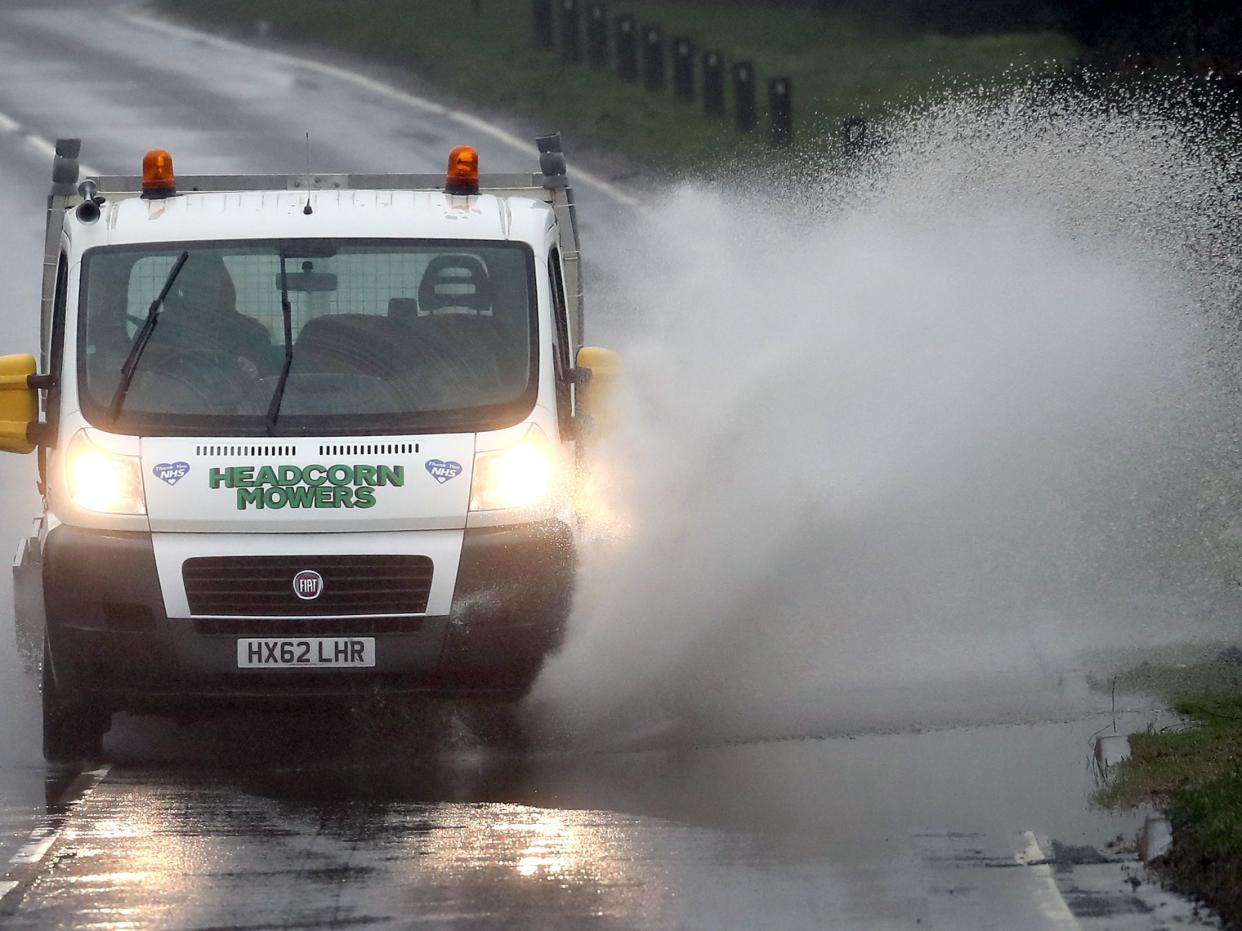 <p>A van splashes through standing water on a road near Canterbury in Kent following heavy rain</p> (PA)