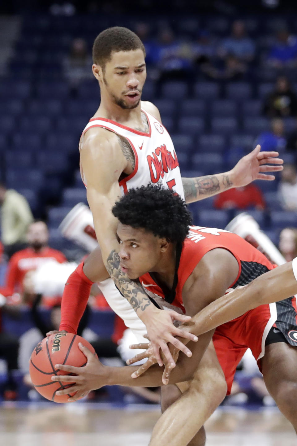 Georgia guard Sahvir Wheeler, bottom, is stopped by Mississippi forward KJ Buffen in the first half of an NCAA college basketball game in the Southeastern Conference Tournament Wednesday, March 11, 2020, in Nashville, Tenn. (AP Photo/Mark Humphrey)