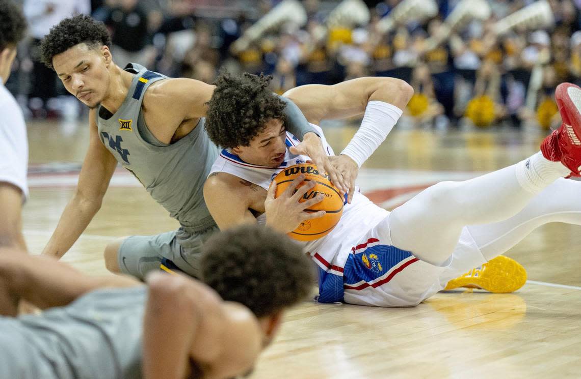 Kansas forward Jalen Wilson (10) fights for possession with West Virginia forward Tre Mitchell (3) during an NCAA college basketball game in the second round of the Big 12 Conference tournament Thursday, March 9, 2023, in Kansas City.