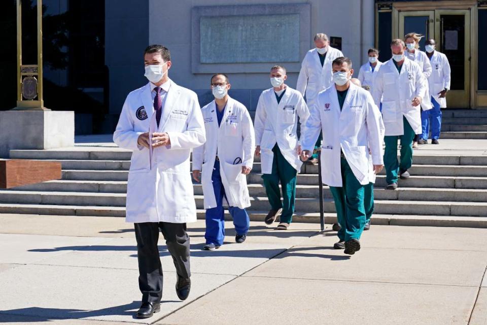 Dr. Sean Conley, physician to President Donald Trump, is followed by a team of doctors for a briefing with reporters at Walter Reed National Military Medical Center in Bethesda, Md.
