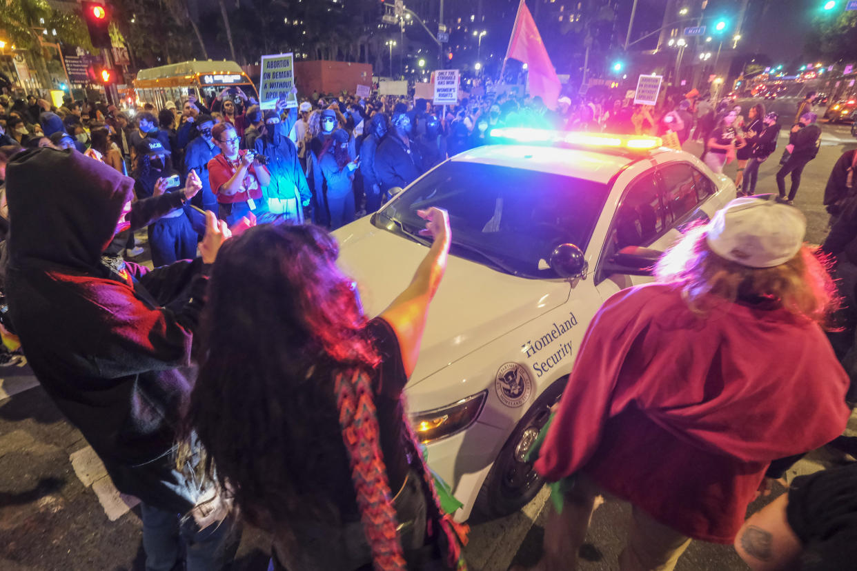 Demonstrators surround a Homeland Security vehiclenear Pershing Square in Los Angeles on Tuesday. (Ringo H.W. Chiu/AP Photo)