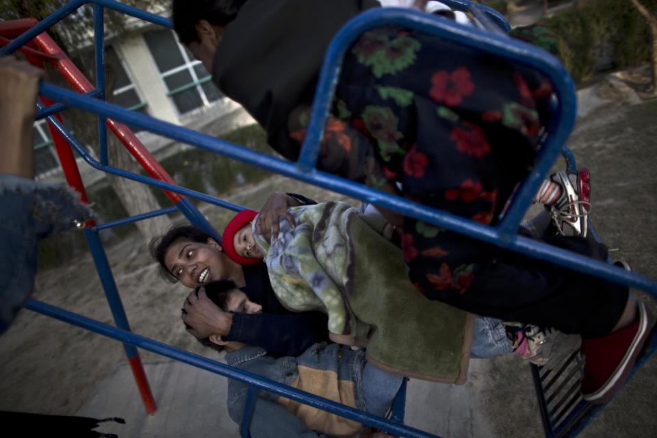 In this Sunday, Feb. 16, 2014, photo, Pakistani nurse Farzana Yassmine, 31, enjoys a swing ride holding Caleb, 1, and Mariam 11, and other patients who live at St. Joseph’s Hospice, at the garden of the hospice, in Rawalpindi, Pakistan. Mohammed Aqeel spent weeks at home in Pakistan waiting for death after suffering a debilitating spinal cord injury in a car crash before friends suggested he come to St. Joseph’s Hospice on the outskirts of the capital, Islamabad. Now 13 years later, his life and those of some 40 others who live on its grounds might be changed forever as this hospital of last resort faces closure over its rising debts. (AP Photo/Muhammed Muheisen)