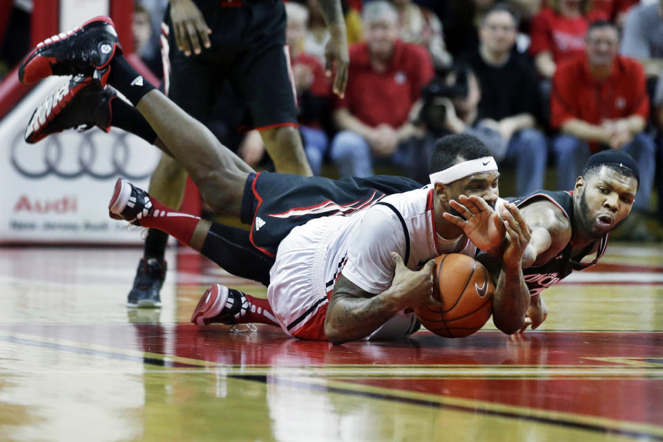 Cincinnati forward Titus Rubles, right, grabs for the ball as he falls over Rutgers forward J.J. Moore during the second half of an NCAA college basketball game Saturday, March 8, 2014, in Piscataway, N.J. Cincinnati won 70-66. (AP Photo/Mel Evans)