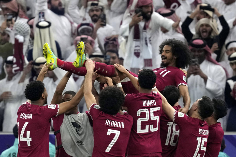 Qatar's players throw Akram Afif in the air as they celebrate Afif's three goals and their victory over Jordan in the Asian Cup final soccer match at the Lusail Stadium in Lusail, Qatar, Saturday, Feb. 10, 2024. (AP Photo/Thanassis Stavrakis)