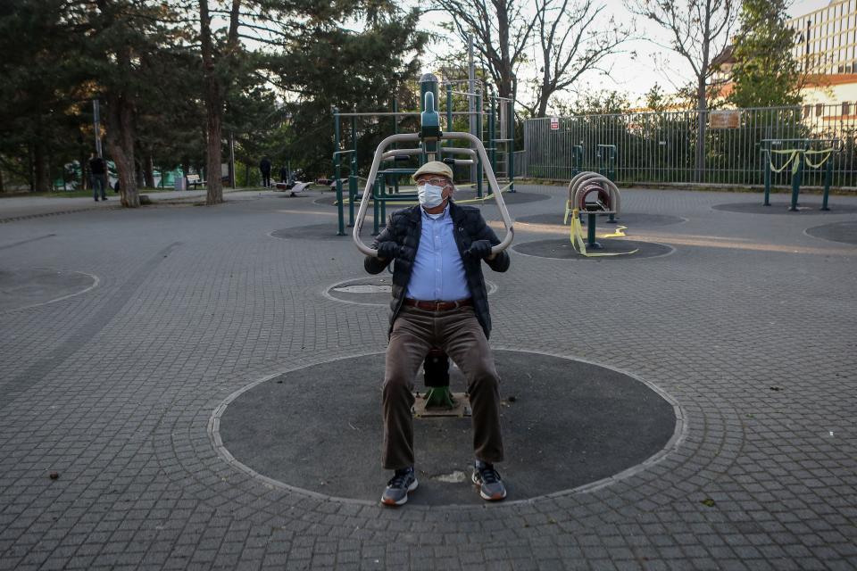 An elderly man exercises in a park in Belgrade on April 21, 2020, amid the COVID-19 outbreak caused by the novel coronavirus. - After almost a month people aged 65-years and older are allowed for the first time out of their homes for 30-minute walks on Tuesdays, Fridays and Sundays between 6pm and 1am, up to 600 metres from their residence. Serbia has introduced curfew from Friday 6 pm to Sunday 5 am for entire population except those authorised and night shift workers, in a bid to fight the COVID-19 disease caused by the novel coronavirus. (Photo by Oliver BUNIC / AFP) (Photo by OLIVER BUNIC/AFP via Getty Images)