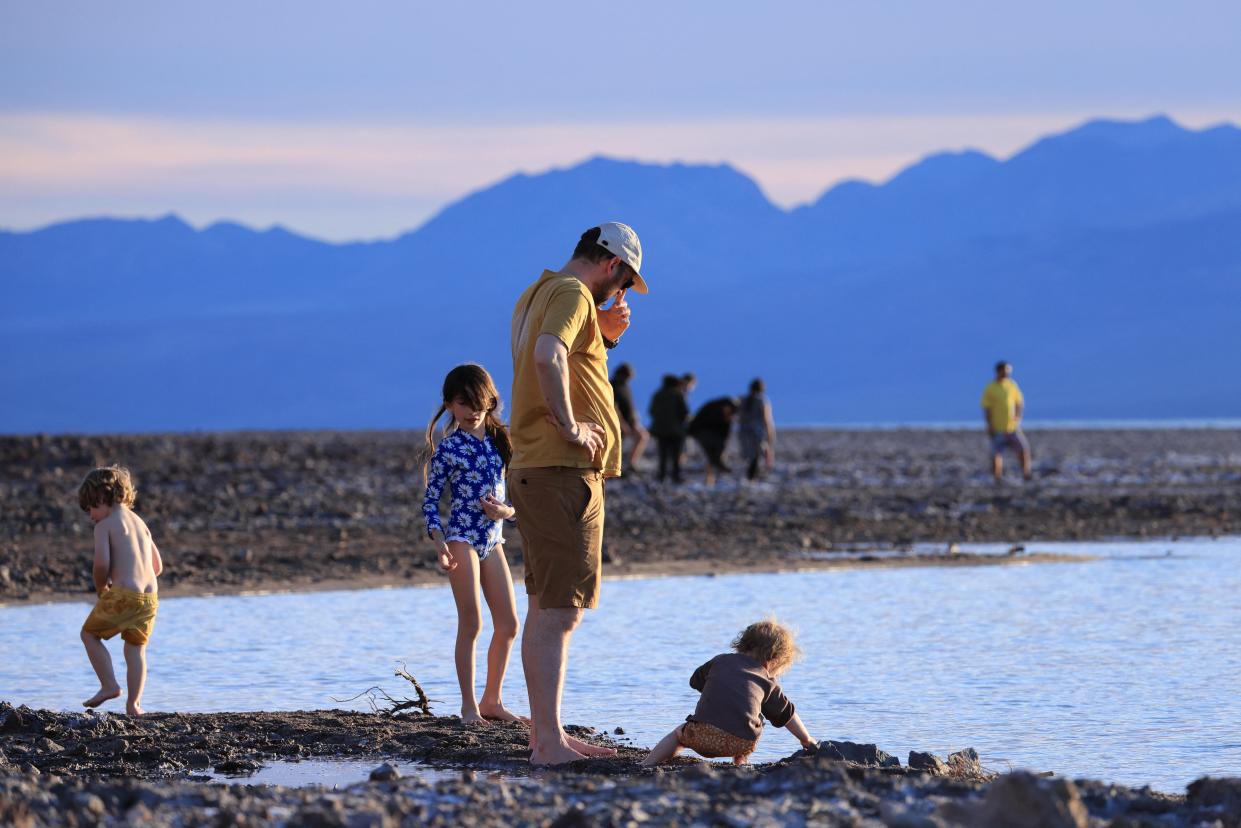 Tourists enjoy the rare opportunity to walk in water Sunday as they visit Badwater Basin, normally the driest place in the United States, in Death Valley National Park. The lowest point in North America, the basin was flooded by Hurricane Hilary in August and recent rains in California.